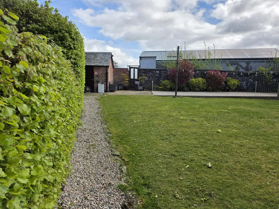 Mown lawn framed by mature garden trees