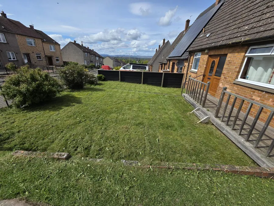 Tidy garden lawn beside a brick wall