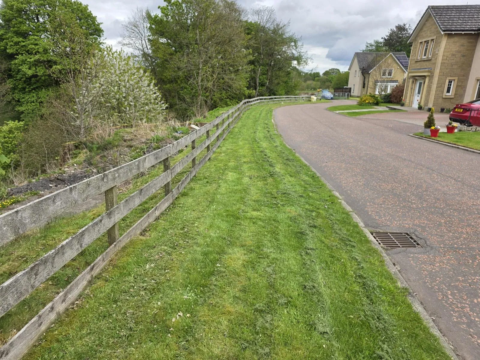 Freshly mown striped lawn running alongside a Perthshire driveway